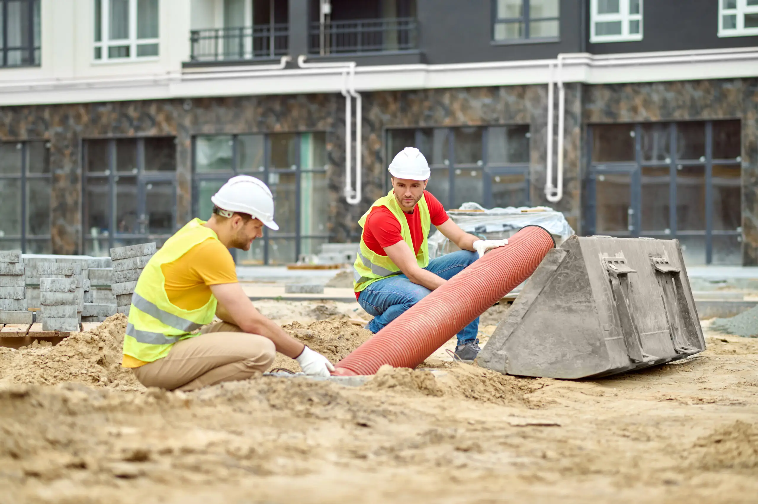 Contractors installing underground drainage piping for a dry well system to manage stormwater runoff at a residential property.